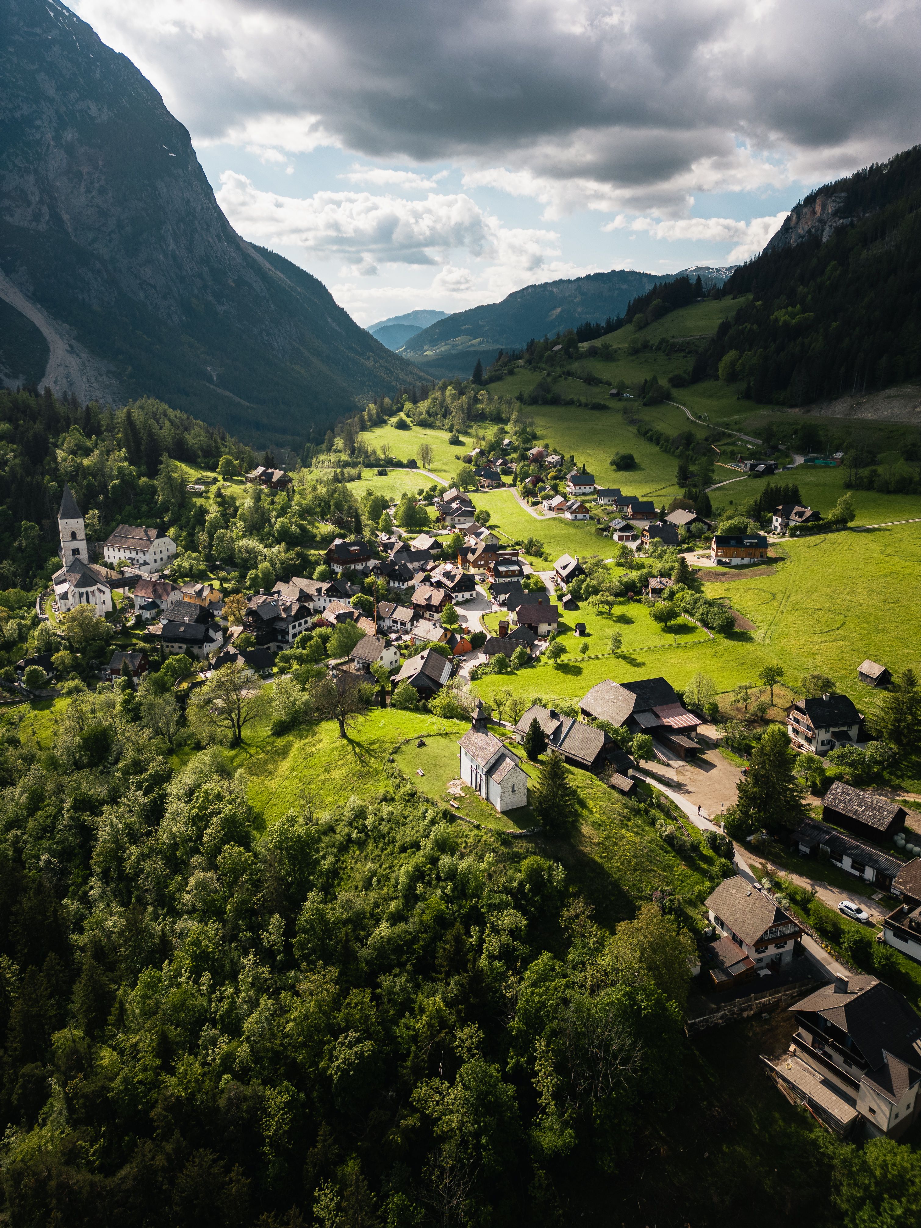Explore the lush green landscapes of Styria with this stunning aerial view of an Alpine village.