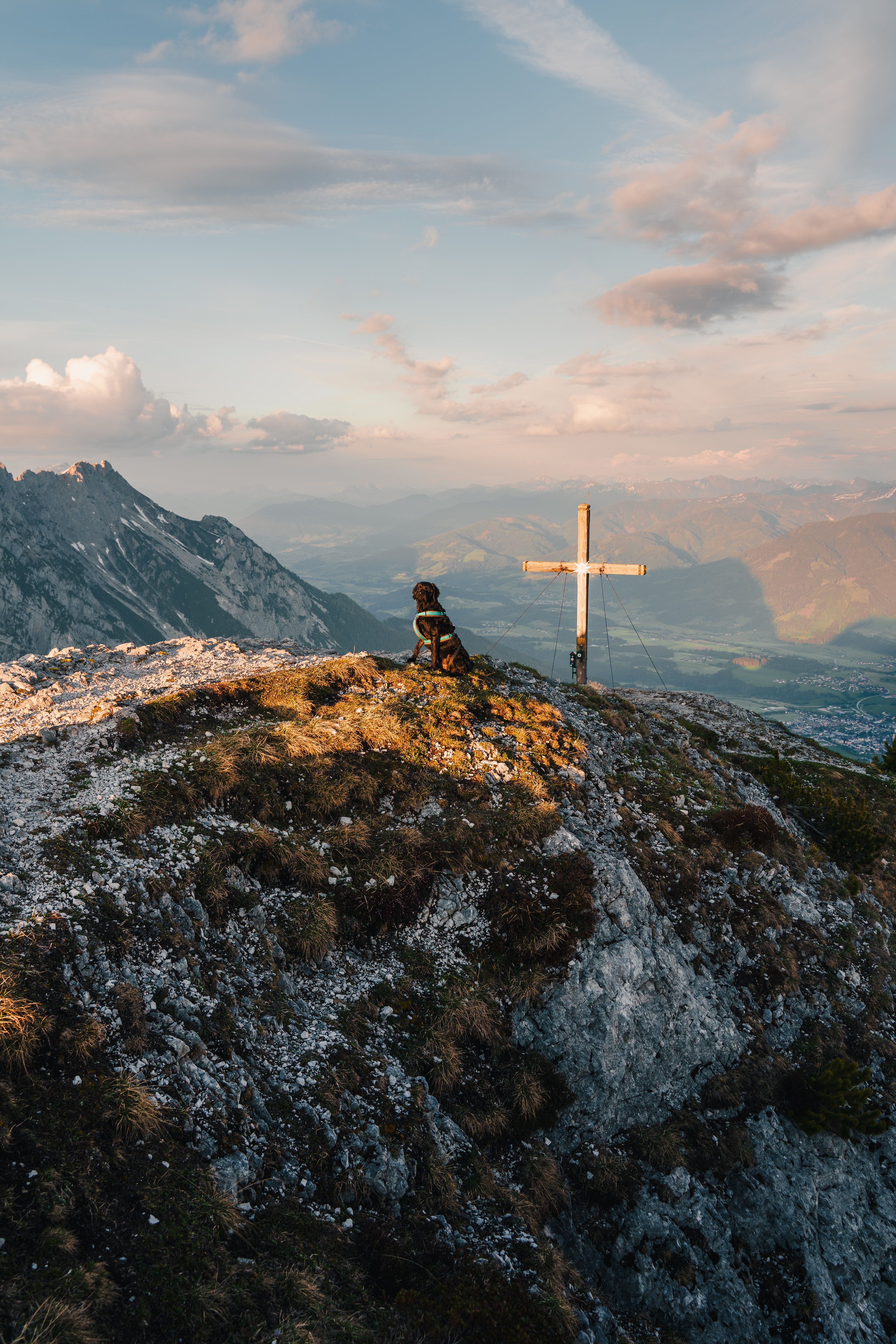 A lone hiker admires the stunning alpine landscape at sunset in the Ennstal Alps, Austria.
