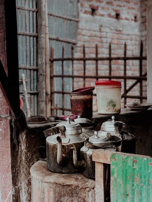 Free A rustic kitchen setup with vintage teapots and containers on a weathered surface, evoking nostalgia. Stock Photo