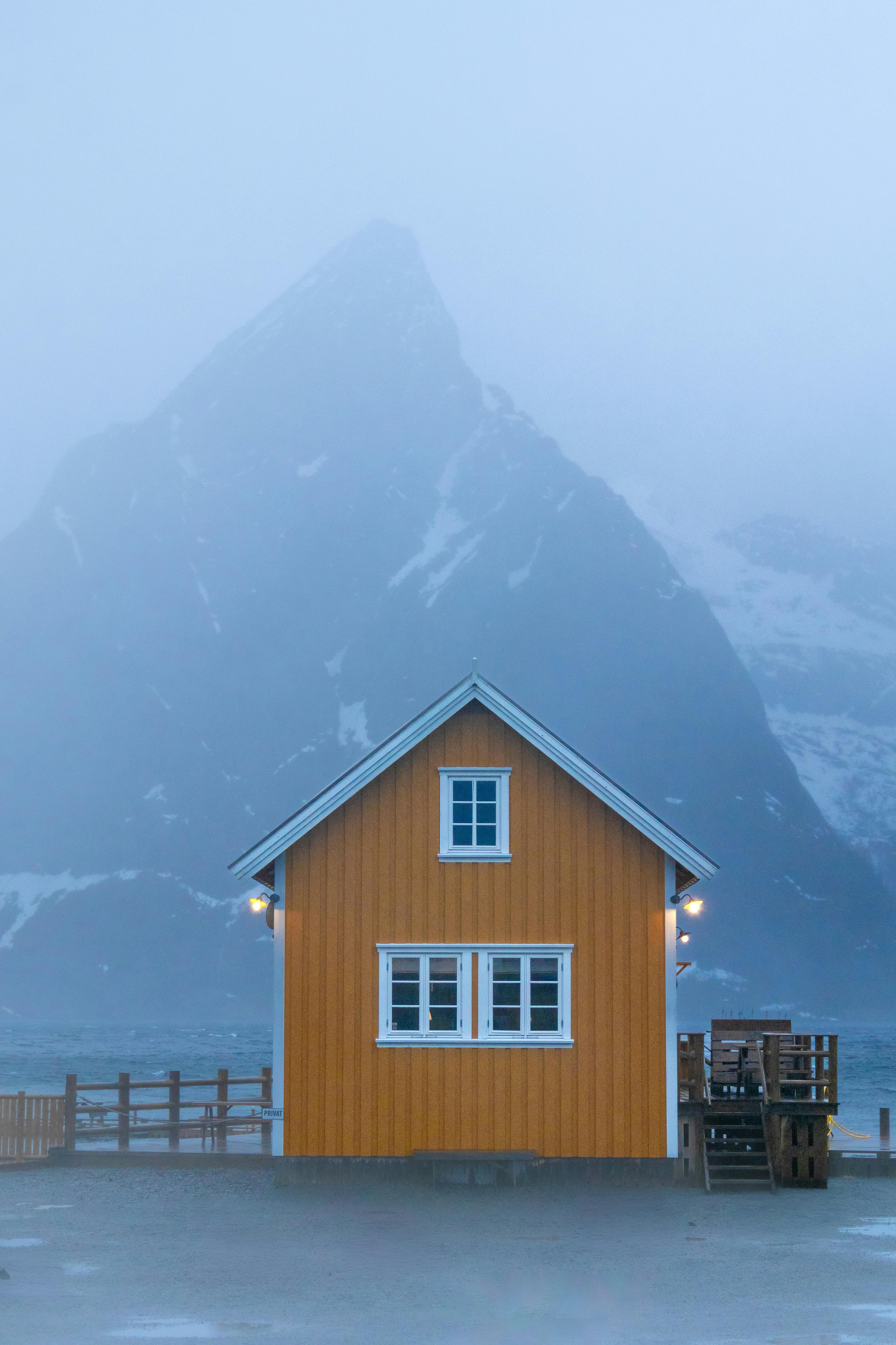 Orange cabin with a misty mountain in the backdrop, creating a serene and tranquil scene.