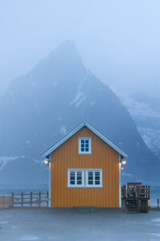 Orange cabin with a misty mountain in the backdrop, creating a serene and tranquil scene.