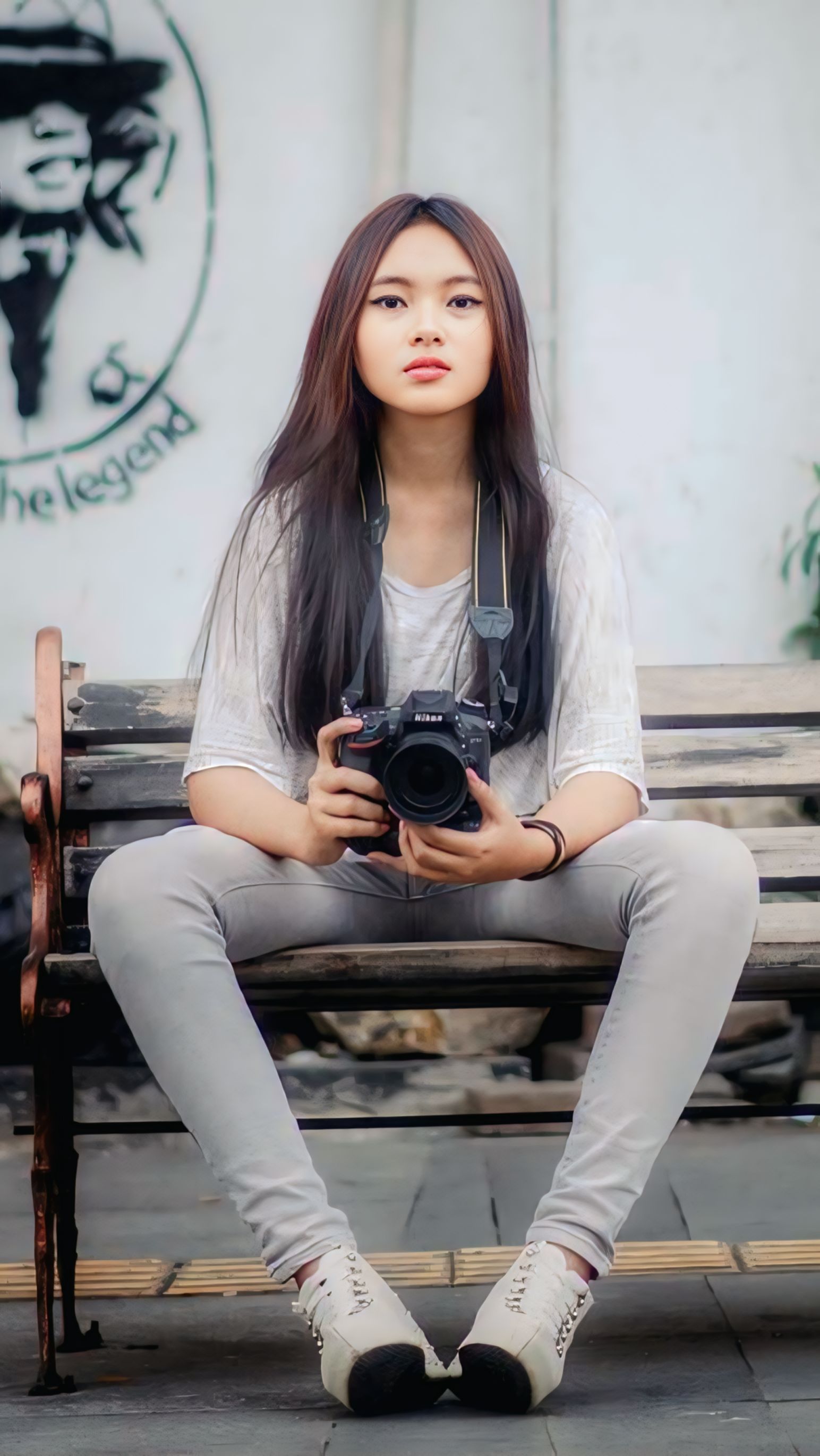 Young Woman with Camera Sitting on Bench