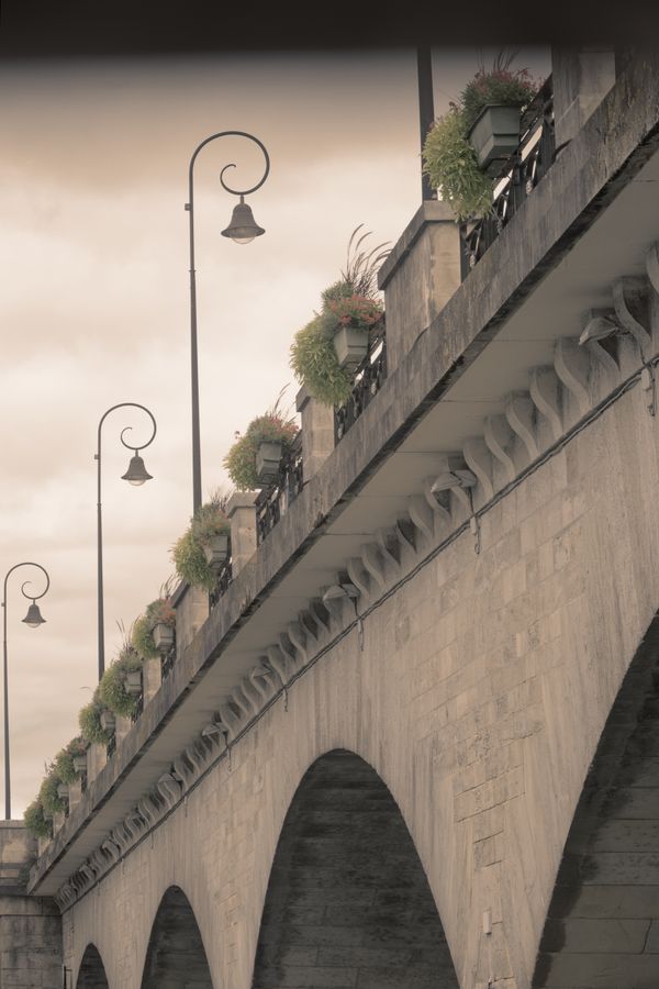 Pont de pierre à arches avec réverbères et jardinières à Cognac