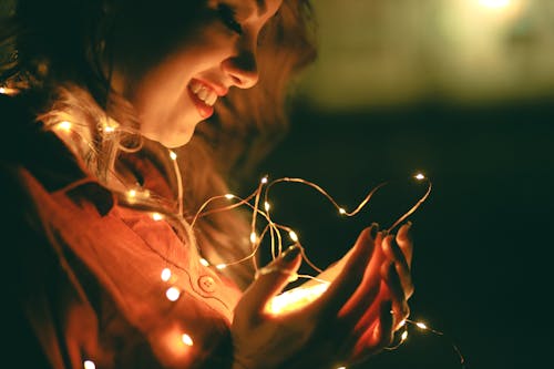 Mulher Segurando Um Cordão De Luz Enquanto Sorri