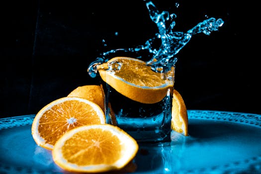 Vibrant orange slices creating a splash in a glass of water, a refreshing and dynamic scene.