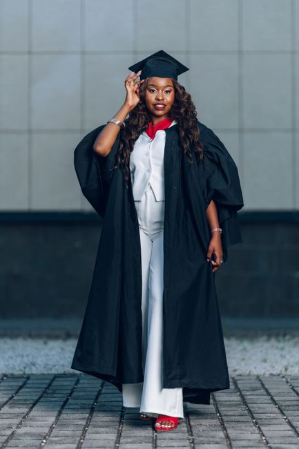 Female graduate posing confidently in academic regalia, celebrating a graduation milestone.