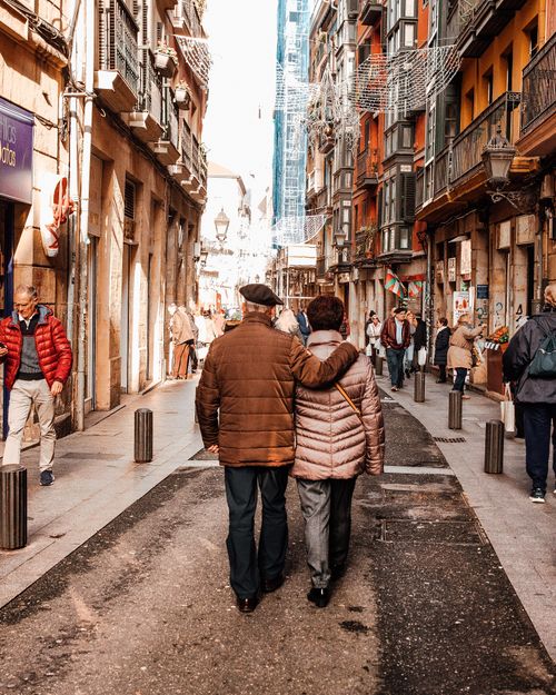 Free Senior couple enjoying a walk in the bustling streets of Bilbao, Spain on a sunny day. Stock Photo