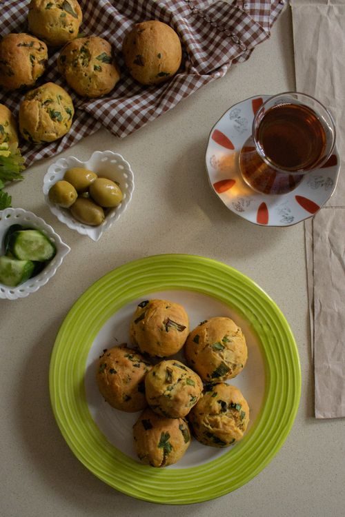 Free A top-down view of a breakfast setup with homemade muffins, tea, olives, and cucumbers. Stock Photo