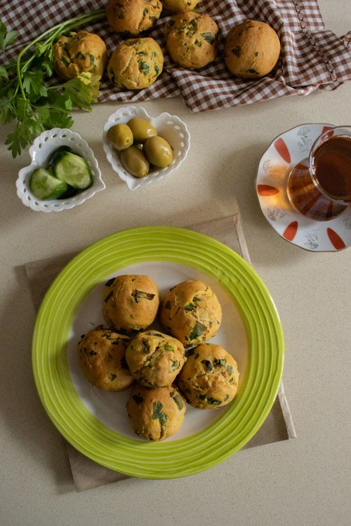 Free Top view of homemade herb biscuits with tea, cucumbers, and olives for a cozy breakfast. Stock Photo