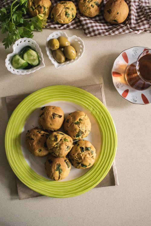 Free Top view of freshly baked herb scones served with tea, olives, and cucumber slices. Stock Photo