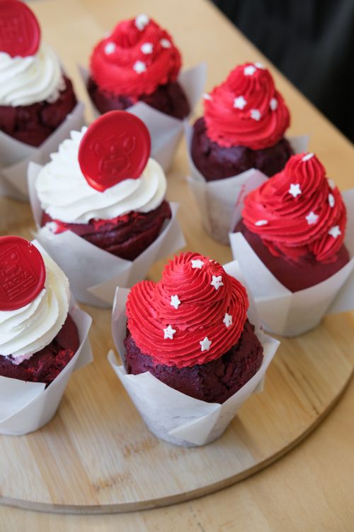 Free Red velvet cupcakes topped with red and white frosting and star sprinkles, perfect for celebrations. Stock Photo