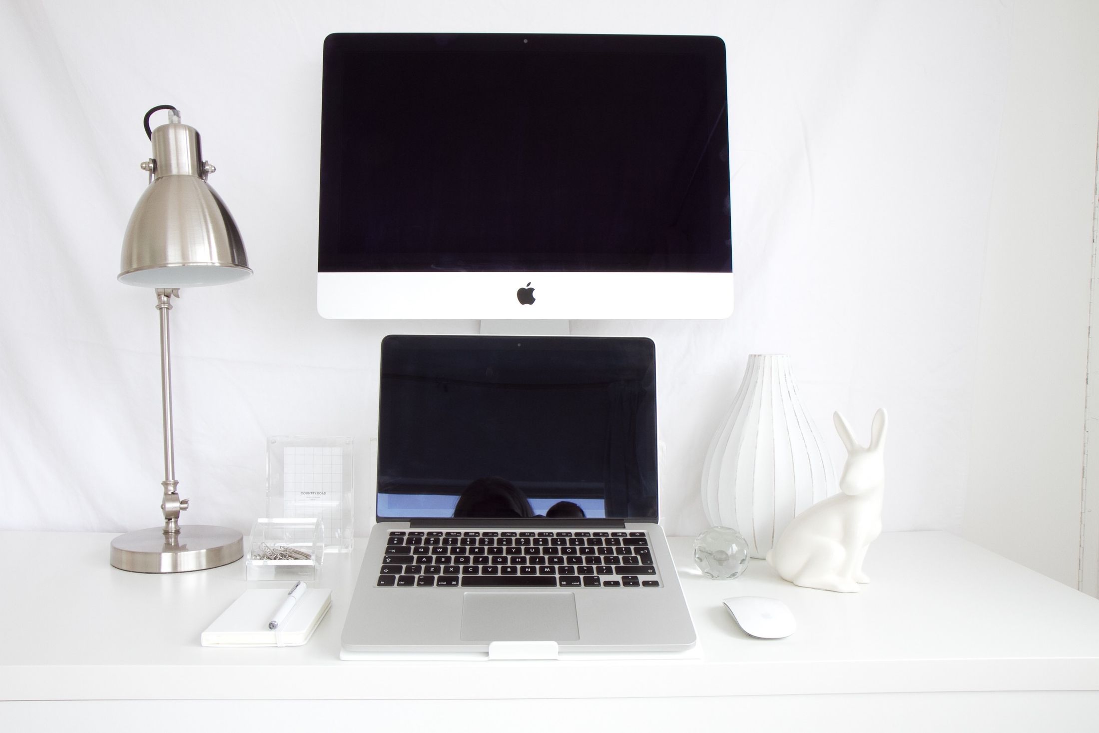 Professional minimalist workspace with laptop, monitor and refined desk accessories