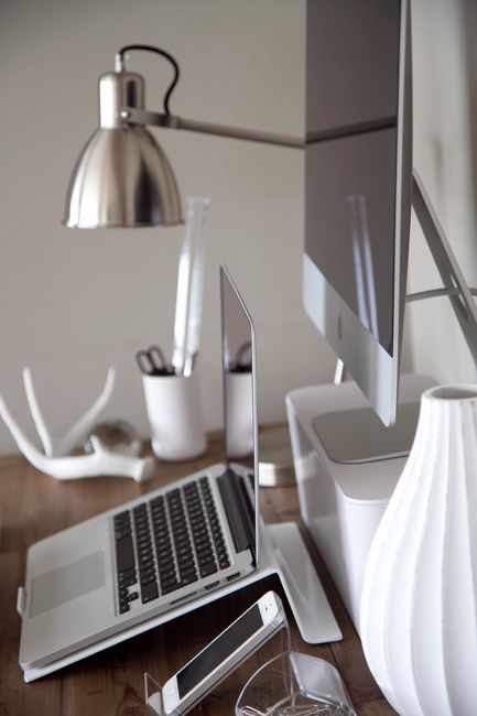 Sleek home office featuring a laptop, desktop, and stylish accessories in a minimalist design.