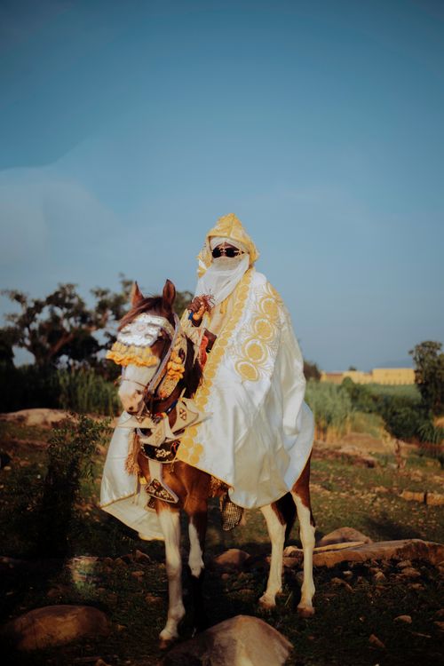 Free A person in traditional attire rides a decorated horse in an outdoor setting. Stock Photo