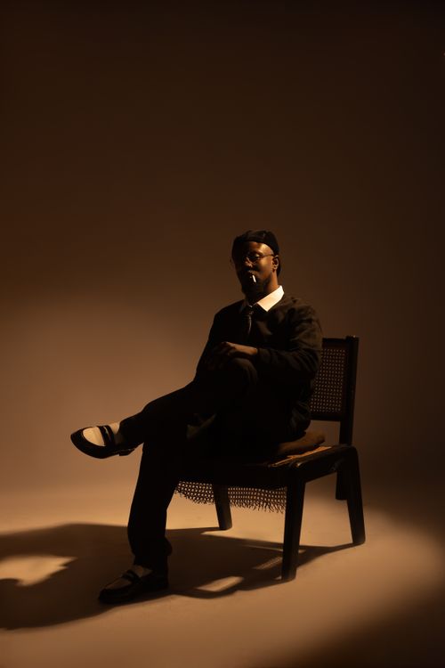 Free Silhouette of a man sitting on a chair in dramatic lighting. Stock Photo
