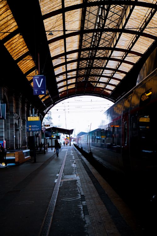 Free A vibrant view of the train station platform in Strasbourg, showcasing a covered structure and a parked train. Stock Photo