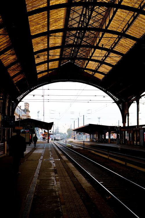 Free View of Strasbourg train station with arched roof and tracks leading into the distance. Stock Photo