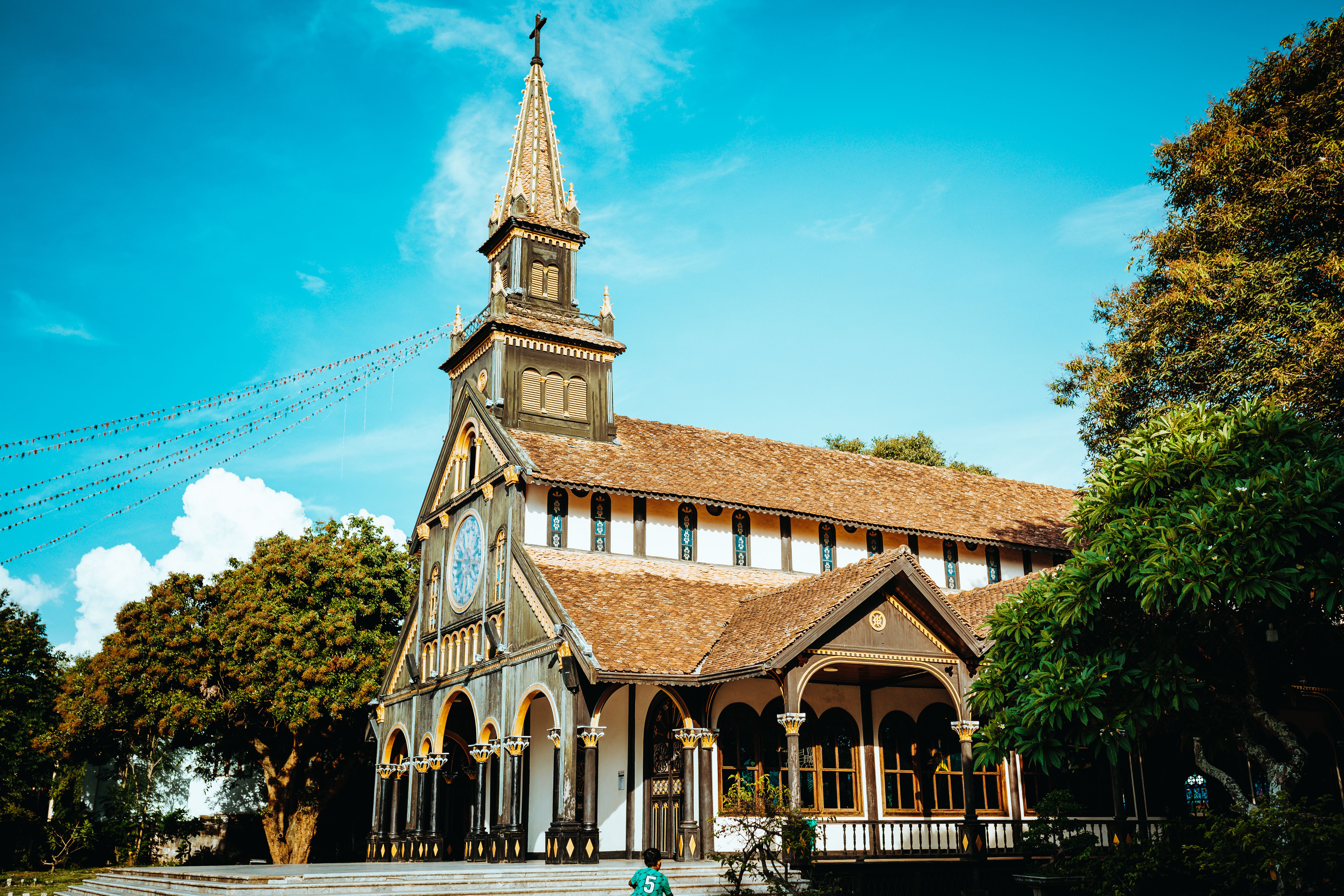 Stunning view of the wooden cathedral in Kon Tum, Vietnam under a bright blue sky.