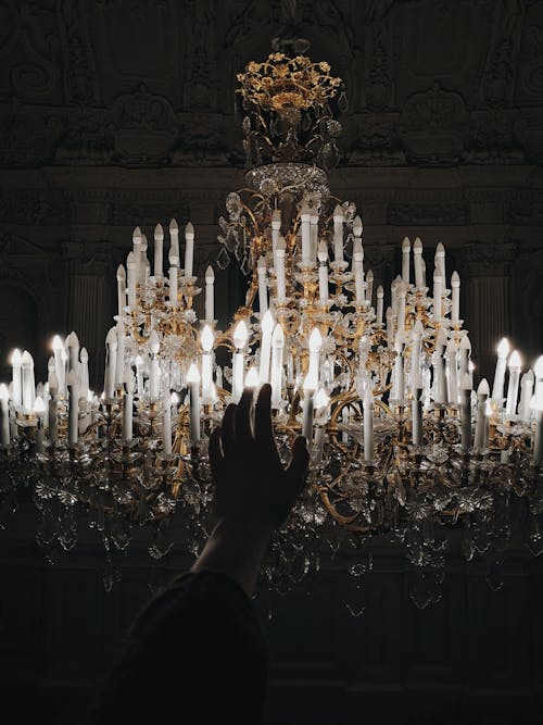 Free Photo Of Person's Hand Near Chandelier Stock Photo