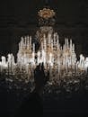 Photo Of Person's Hand Near Chandelier