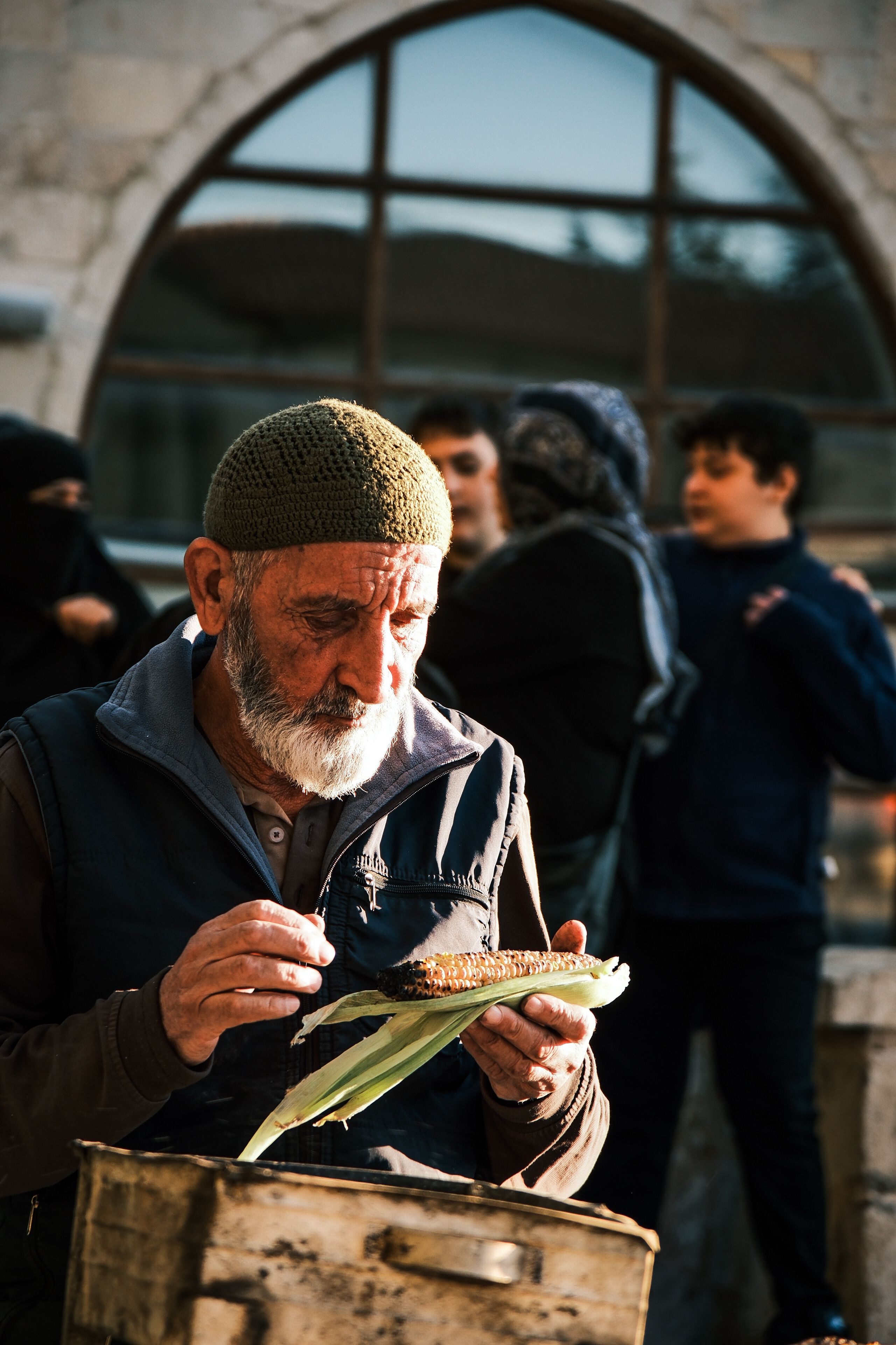Elderly Man Enjoying Corn at Street Market · Free Stock Photo