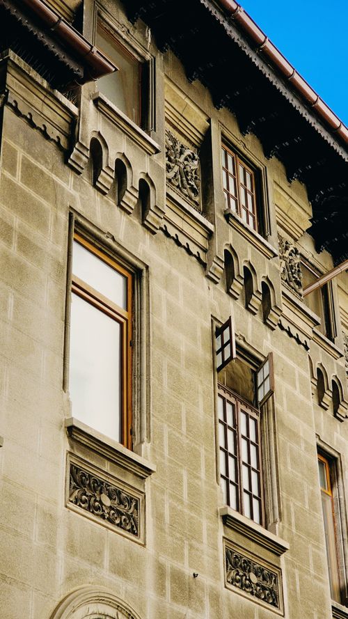 Free Close-up of historic architectural detail on a building in Bucharest, Romania, showcasing ornate window design and decorative elements. Stock Photo