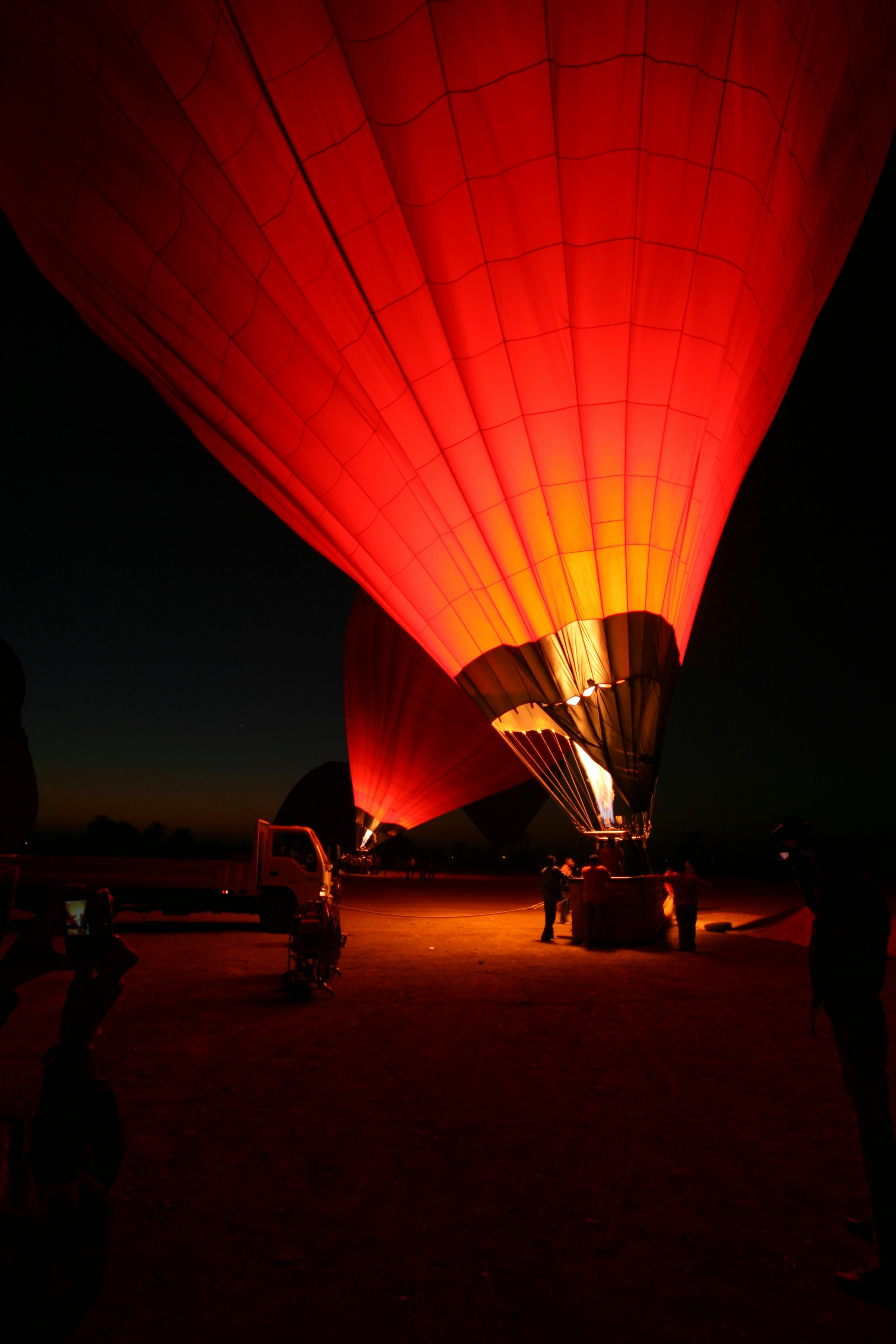 Vibrant hot air balloons being prepared for takeoff during sunrise in Luxor, Egypt.