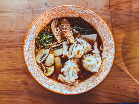 A mouthwatering bowl of dumplings and noodles with vegetables, captured in Dhaka, Bangladesh.
