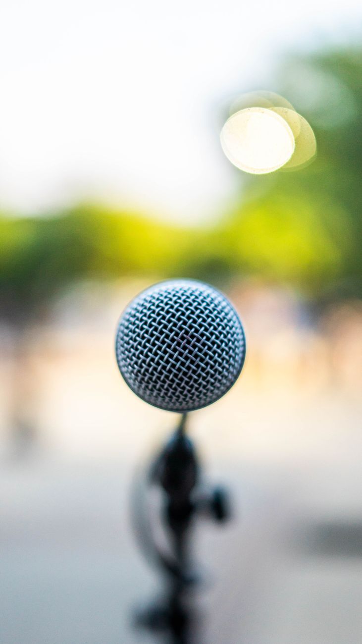 Een microfoon op een standaard buiten, klaar voor een openbare toespraak of een muzikaal optreden.