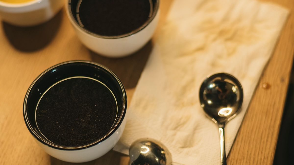 Set de degustare cafea cu cești și linguri de cupping — instrumentul standard SCA pentru a evalua retenția aromatică post-decofeinizare.