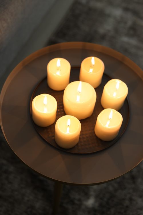 Free A serene arrangement of glowing candles on a round table creates a warm ambiance. Stock Photo