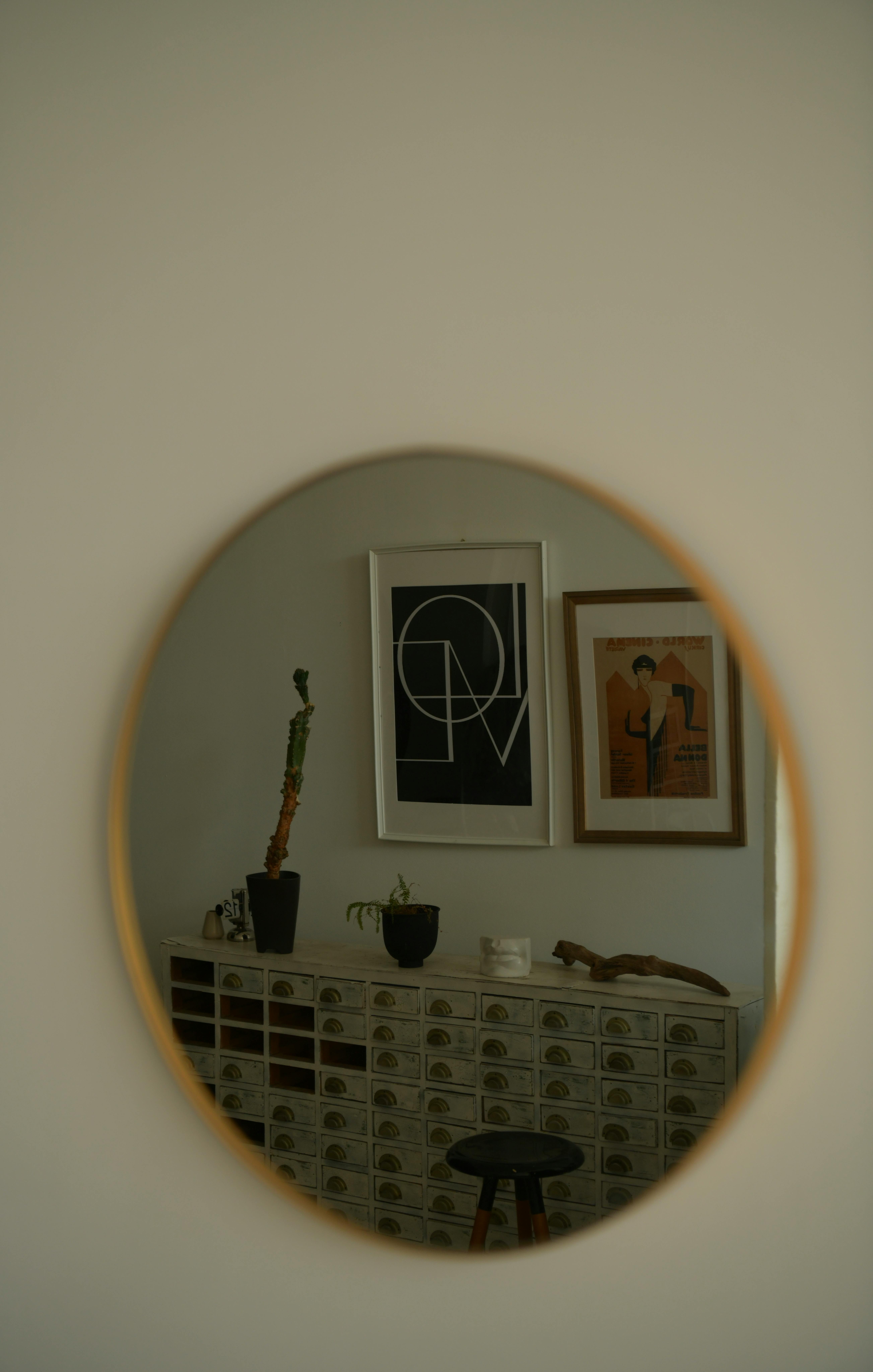 Free Stylish interior with framed art seen in a circular mirror reflection. Stock Photo