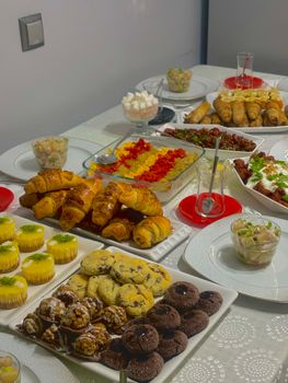 Savor a delightful buffet spread featuring croissants, cookies, and a variety of savory dishes.