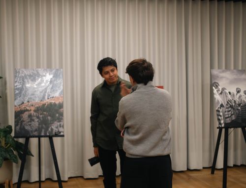Free Two people engaged in conversation at an art gallery with photo exhibits. Stock Photo