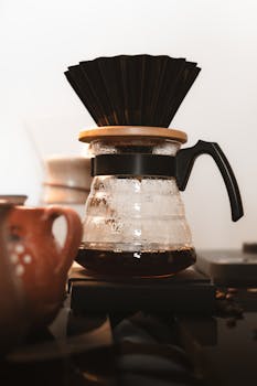 Elegant glass pour-over coffee equipment with filter, creating artisan coffee experience.