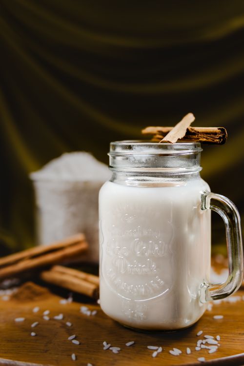 Free Classic Mexican horchata with cinnamon sticks in a rustic setting. Perfect for refreshing non-alcoholic enjoyment. Stock Photo