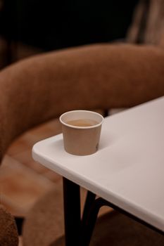 A warm, peaceful cafe scene with a minimalist coffee cup on a table.