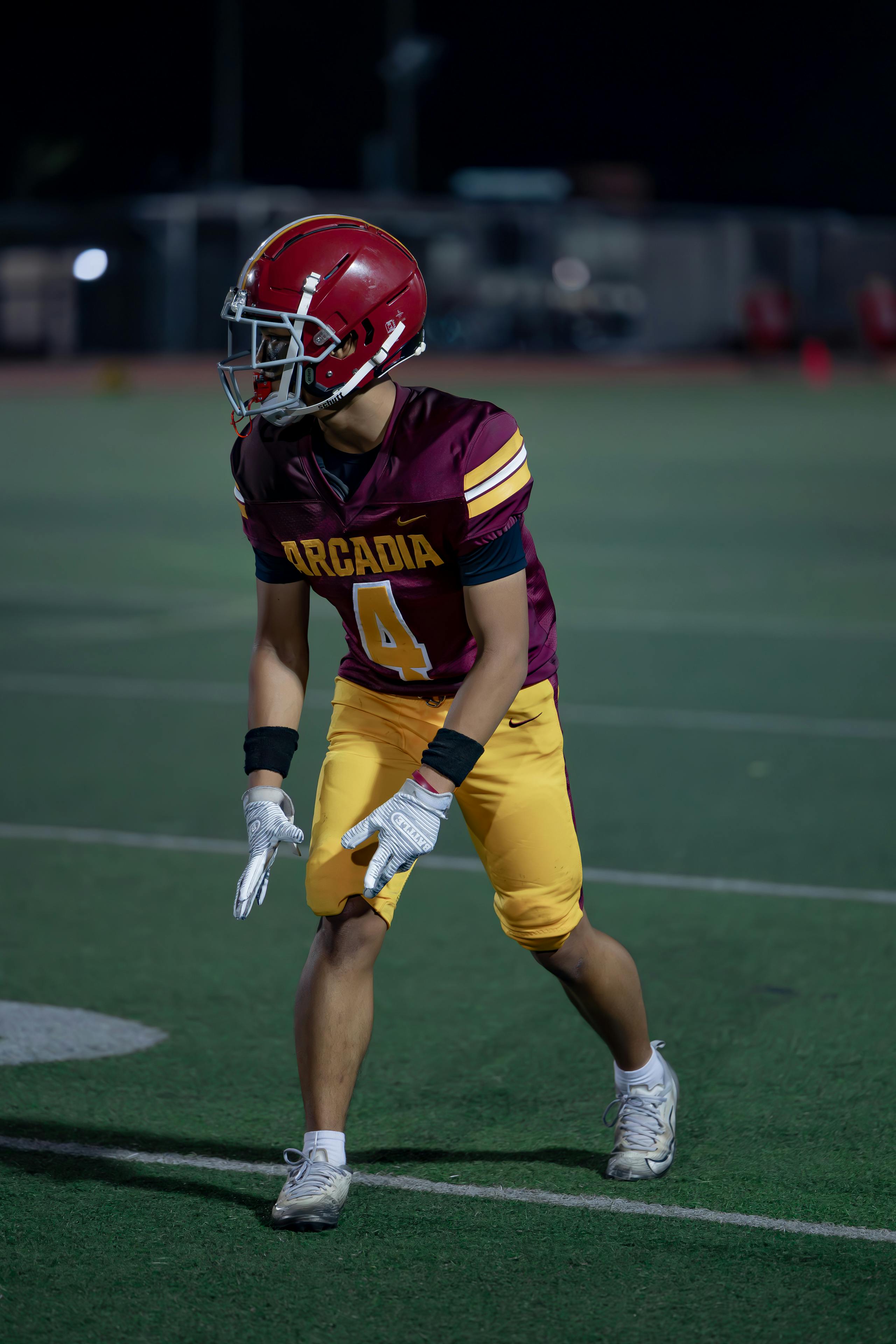 Young football player in action under stadium lights.