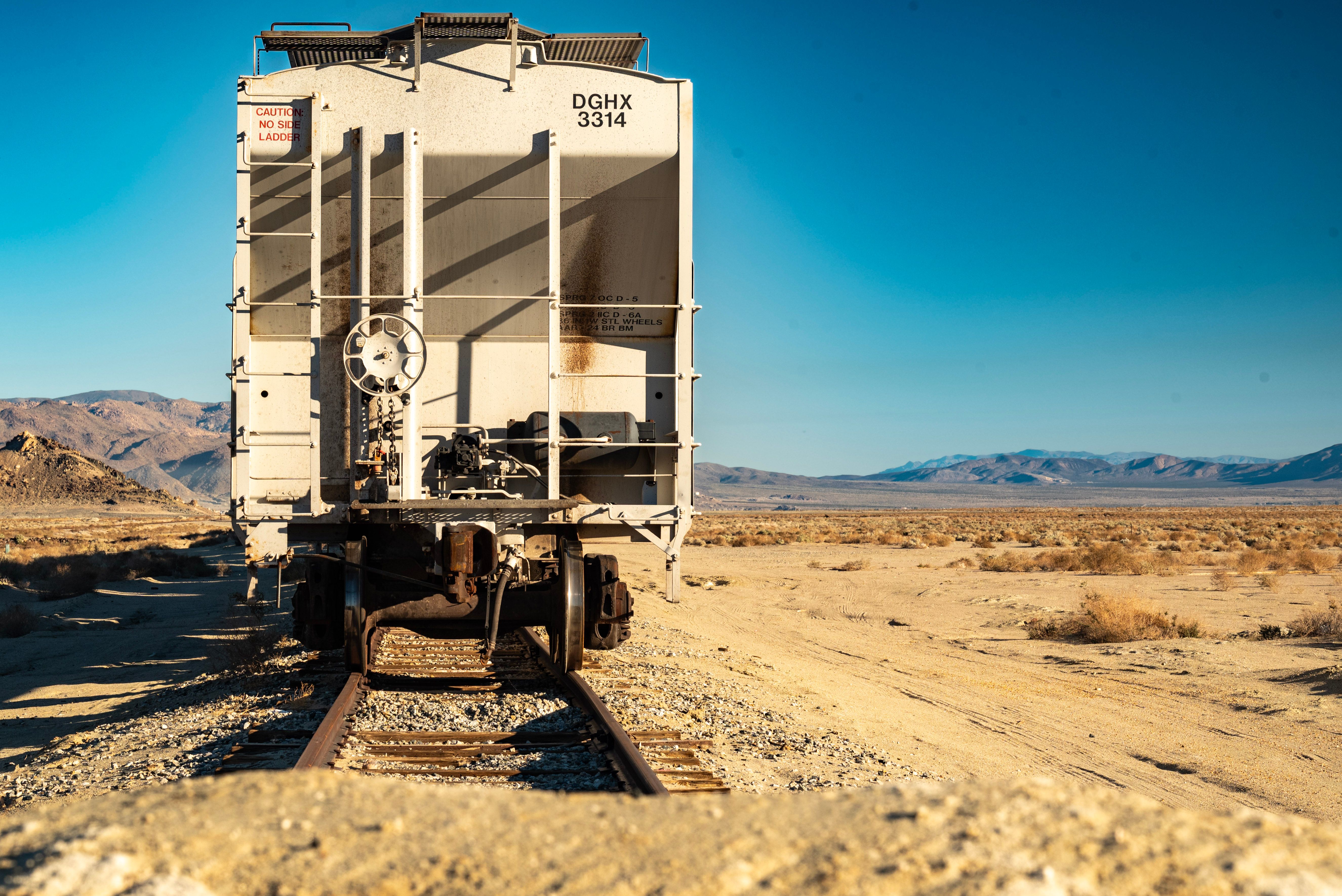 A solitary train car on tracks in the arid Searles Valley desert, California.