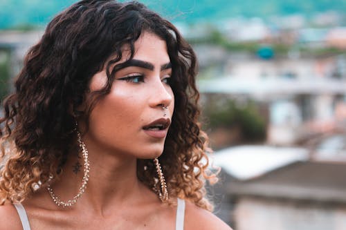 Wanita Mengenakan Anting Hoop Warna Emas Dan Perhiasan Tindik Hidung