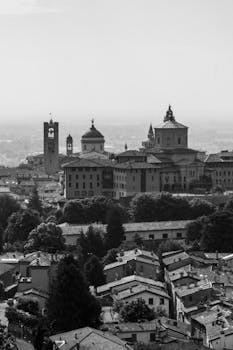 A scenic black and white panorama of Bergamo's historic architecture and rooftops.