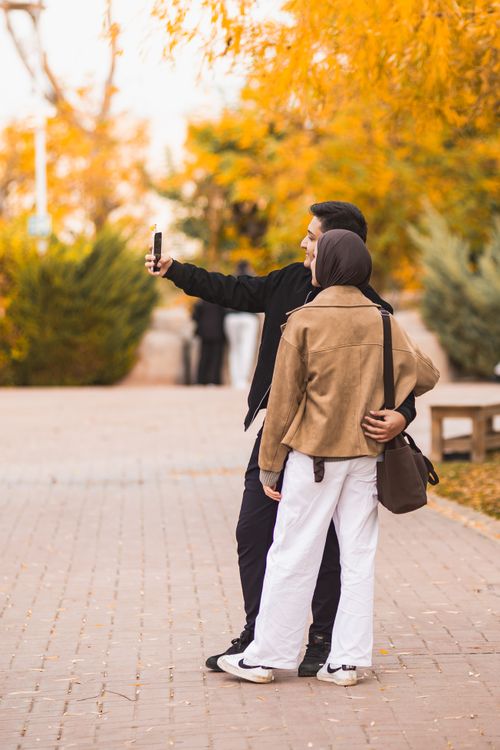 Free Couple capturing a happy moment with a selfie in a beautiful autumn park in Eskişehir, Türkiye. Stock Photo