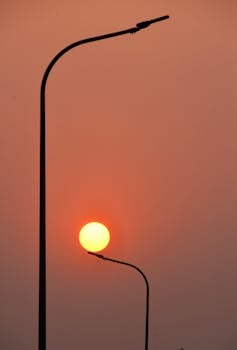 Artistic sunset view with silhouetted streetlights in Hà Nội, Việt Nam.