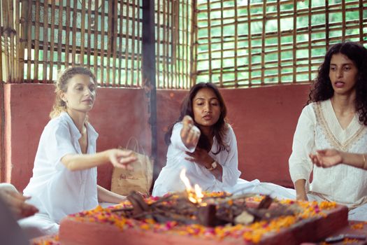 Women participating in a traditional spiritual ceremony in Rishikesh, India.