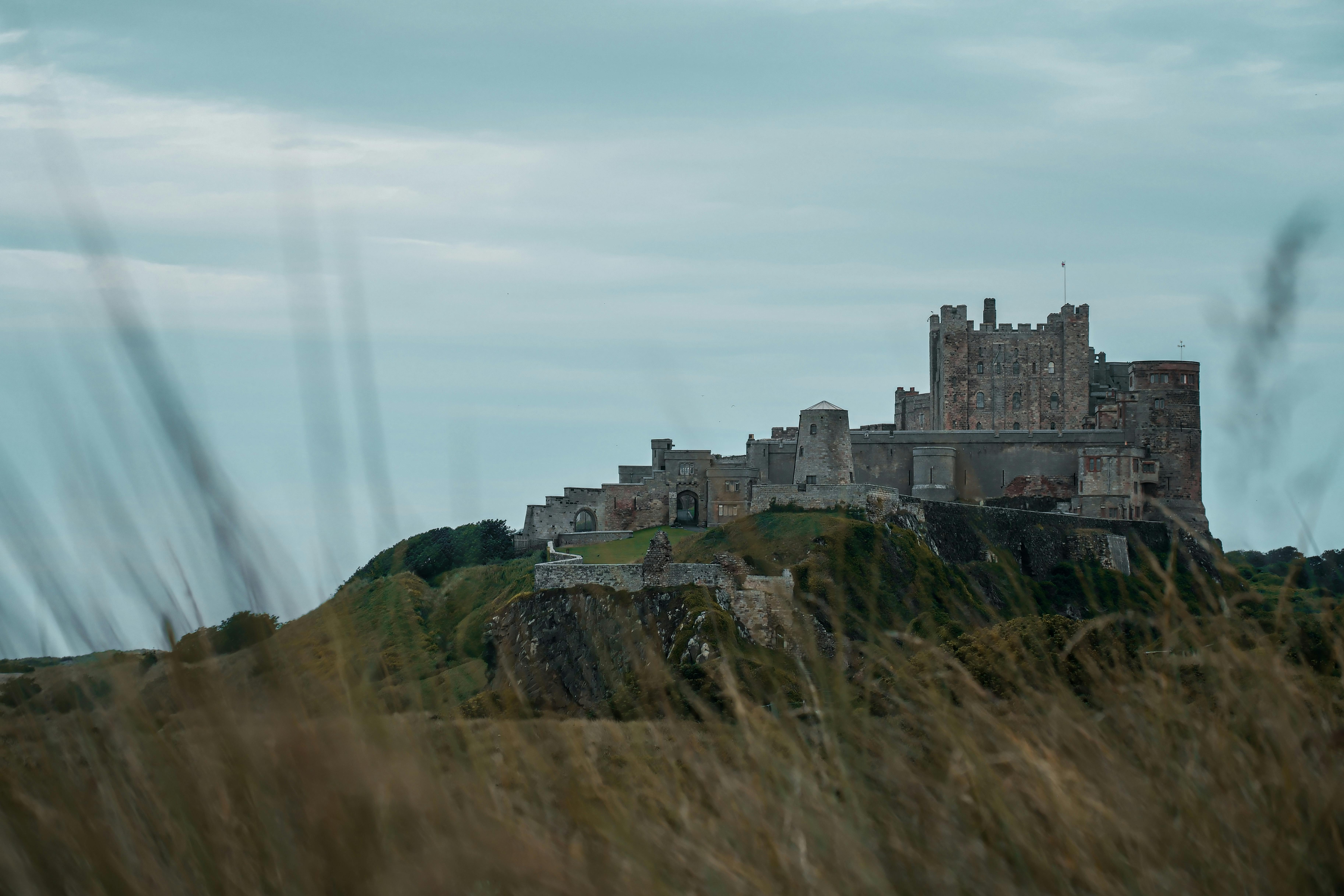 Majestic view of Bamburgh Castle surrounded by natural landscape in England.