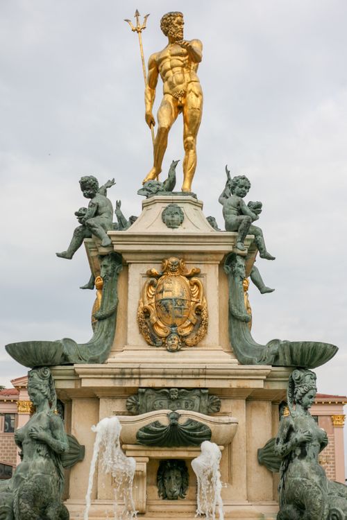 Free Stunning view of the Neptune Fountain featuring gold and bronze sculptures with water flowing. Stock Photo