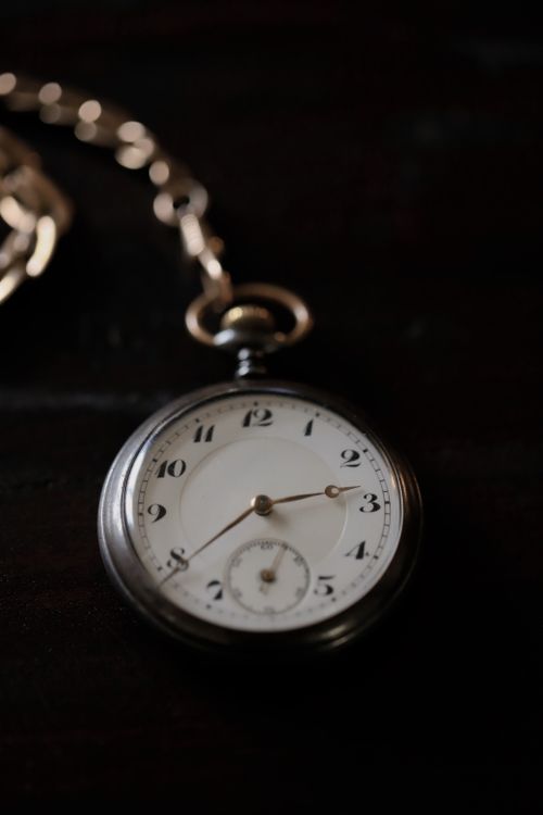 Free Close-up of an antique pocket watch on a dark surface, evoking classic elegance. Stock Photo