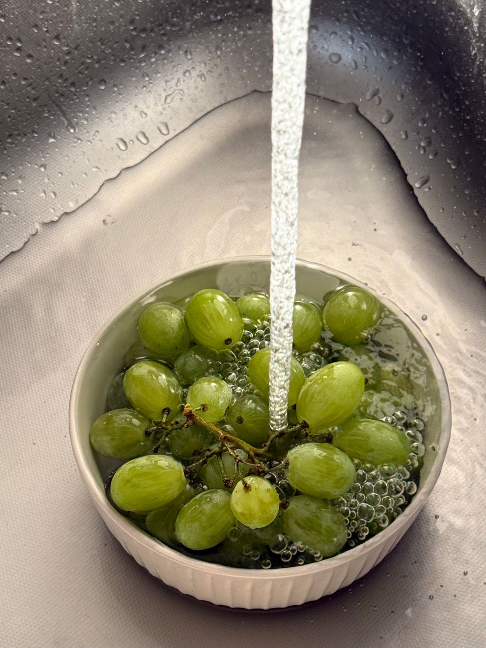 Fresh green grapes being rinsed, reflecting the ordinary whole-food context of the intervention rather than a supplement-style promise