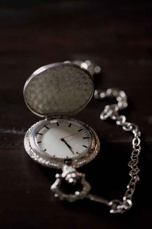 Free Close-up of an antique pocket watch with a chain, showcasing classic elegance and timeless design. Stock Photo