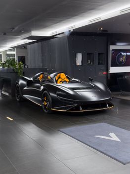 Black supercar with orange interior in a modern showroom, Prague, Czechia.